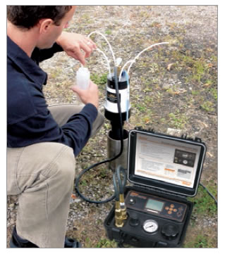Field Technicial Taking Groundwater Samples at Waterloo System Wellhead Manifold field technicial taking groundwater samples at waterloo system wellhead manifold